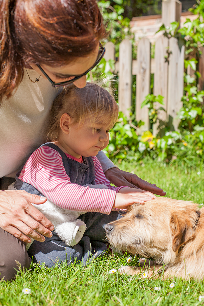 A mother and a child touching their dog